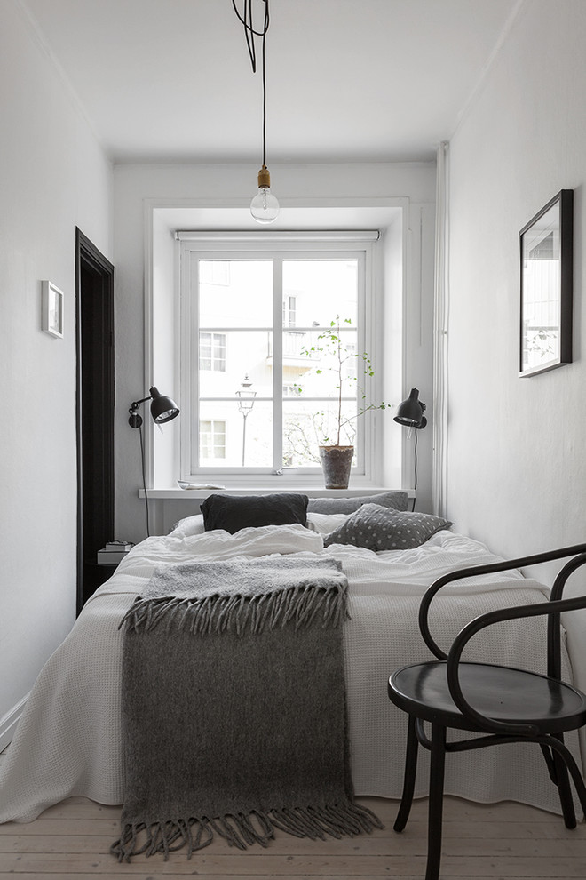 Стильный дизайн: маленькая хозяйская, серо-белая спальня в скандинавском стиле с белыми стенами и светлым паркетным полом без камина для на участке и в саду - последний тренд