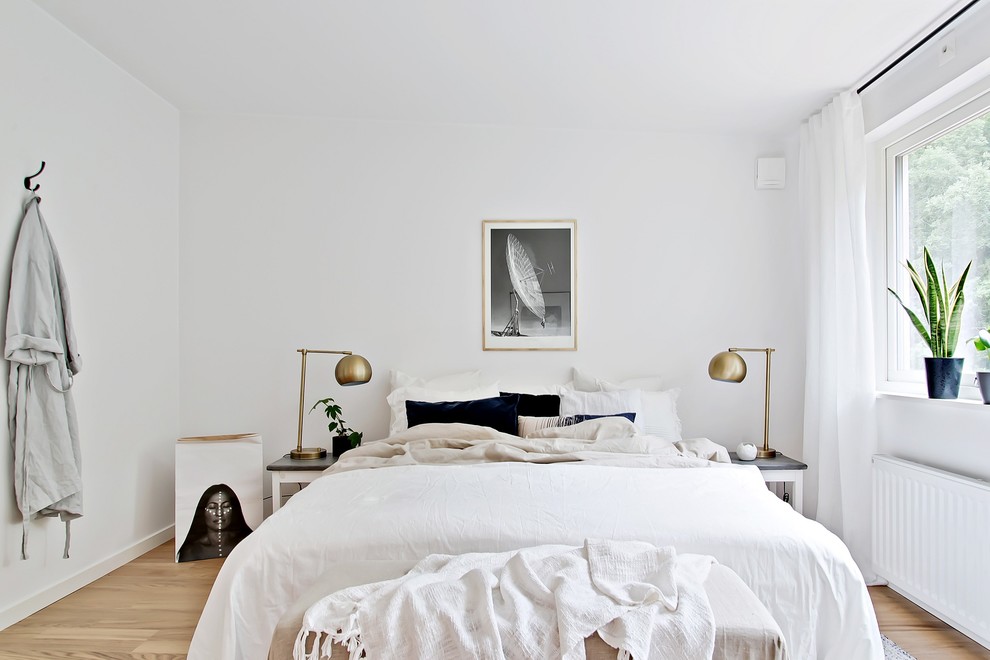 На фото: хозяйская спальня среднего размера в скандинавском стиле с белыми стенами и светлым паркетным полом без камина