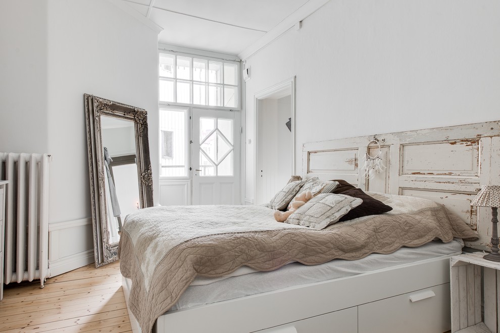 Immagine di una camera matrimoniale shabby-chic style di medie dimensioni con pareti bianche, parquet chiaro e nessun camino