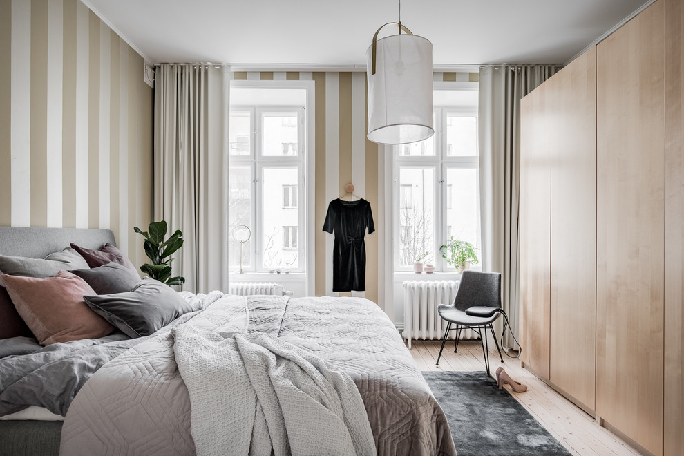 ヨーテボリにある中くらいな北欧スタイルのおしゃれな主寝室 (マルチカラーの壁、淡色無垢フローリング、ベージュの床) のレイアウト