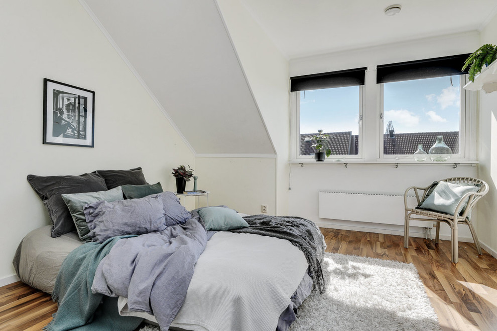 Skandinavisches Schlafzimmer ohne Kamin mit weißer Wandfarbe und hellem Holzboden in Stockholm
