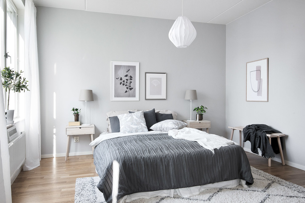 Idéer för ett skandinaviskt gästrum, med grå väggar, mellanmörkt trägolv och brunt golv