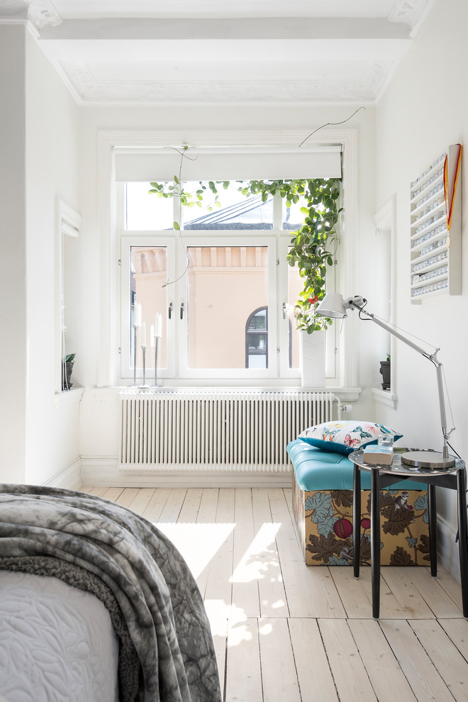 This is an example of a scandinavian bedroom in Malmo with light hardwood flooring and beige floors.