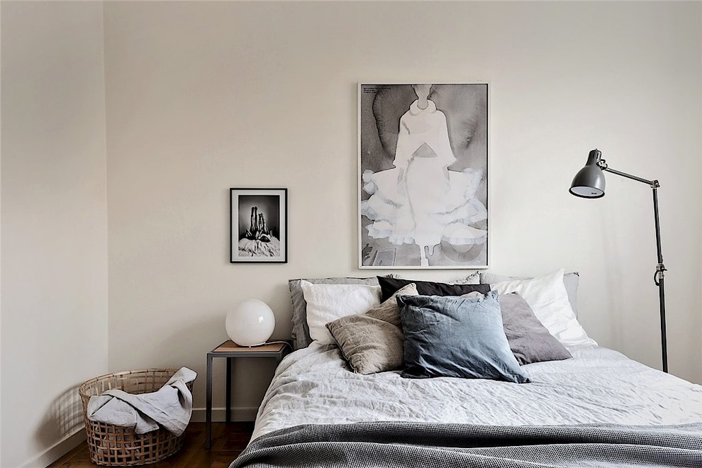 На фото: гостевая спальня (комната для гостей) в скандинавском стиле с бежевыми стенами, темным паркетным полом и коричневым полом без камина с