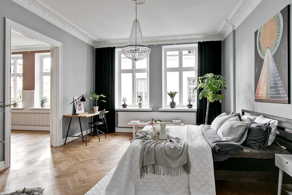 Example of a danish master medium tone wood floor and beige floor bedroom design in Other with gray walls