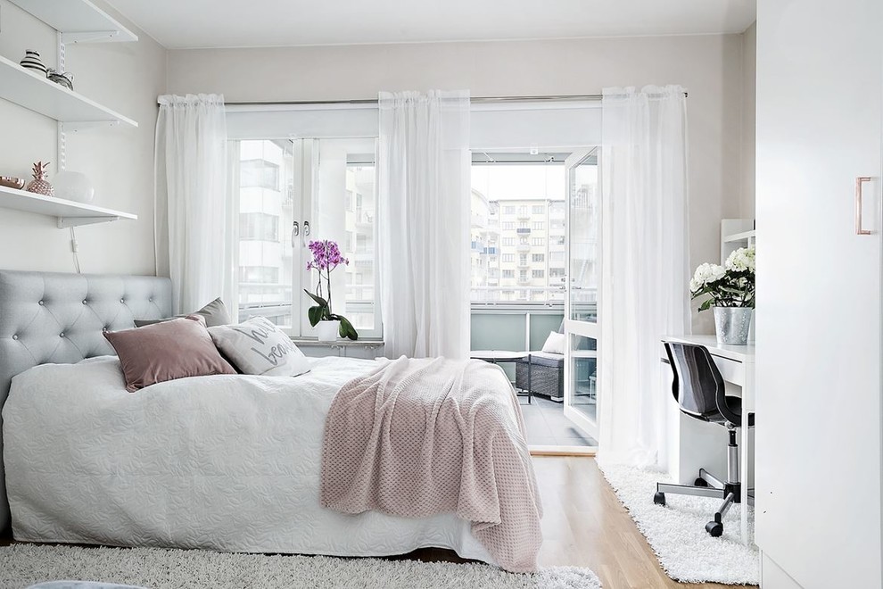 Modelo de dormitorio principal tradicional renovado de tamaño medio con paredes blancas, suelo laminado y con escritorio