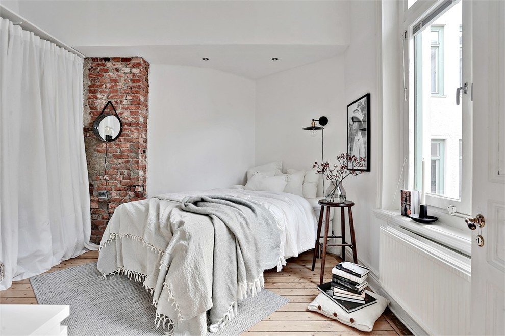 ヨーテボリにある中くらいな北欧スタイルのおしゃれな主寝室 (白い壁、淡色無垢フローリング)
