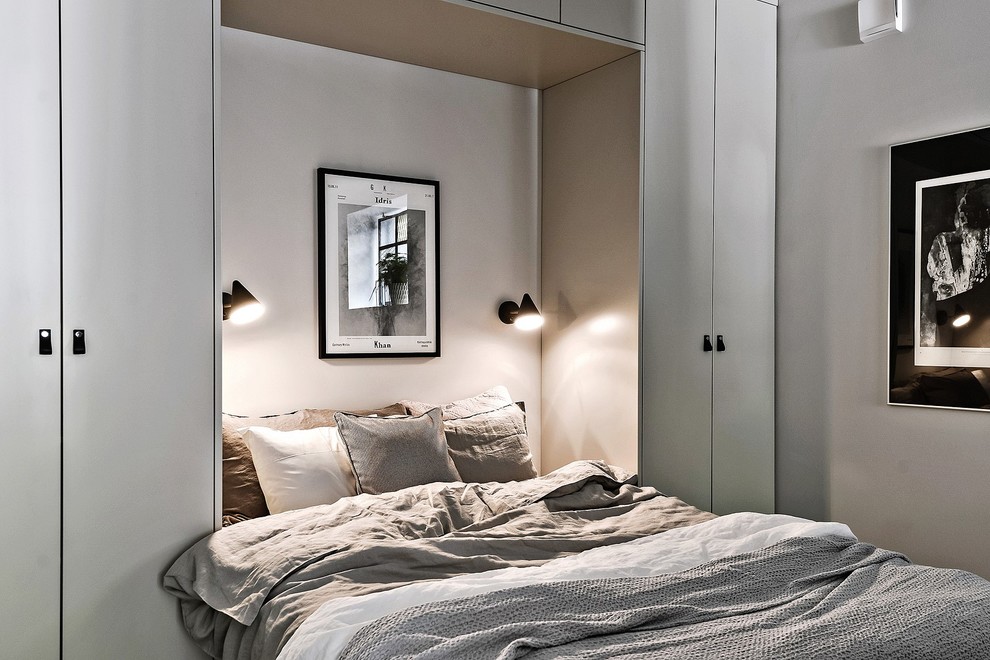 На фото: хозяйская спальня среднего размера в скандинавском стиле с серыми стенами без камина с