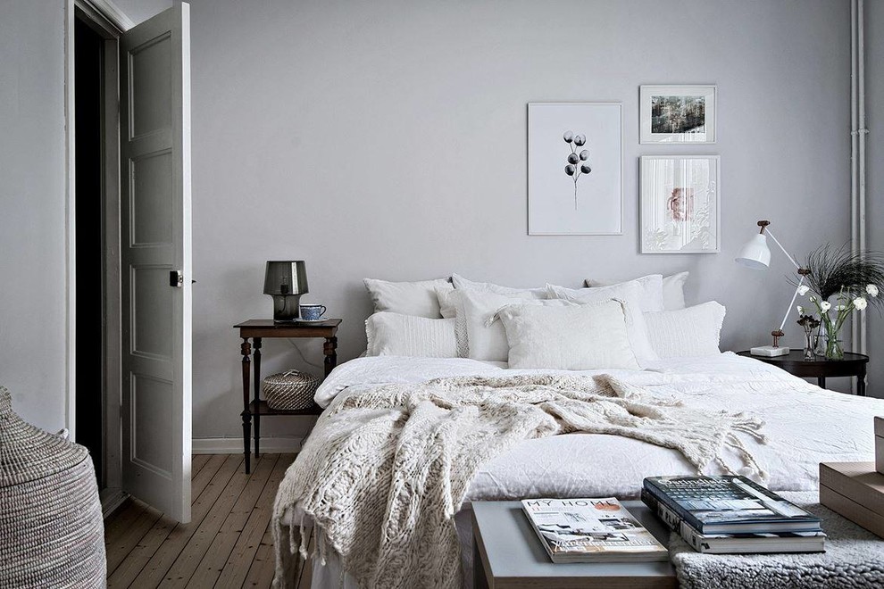 ヨーテボリにある広い北欧スタイルのおしゃれな主寝室 (白い壁、淡色無垢フローリング) のインテリア