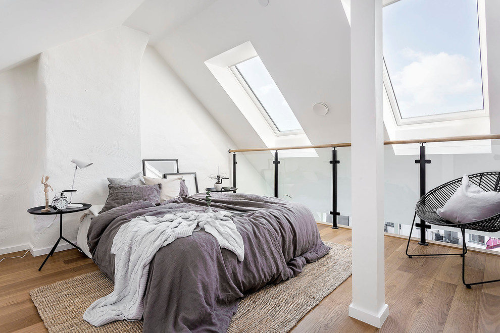 Mittelgroßes Nordisches Hauptschlafzimmer ohne Kamin mit weißer Wandfarbe und braunem Holzboden in Stockholm