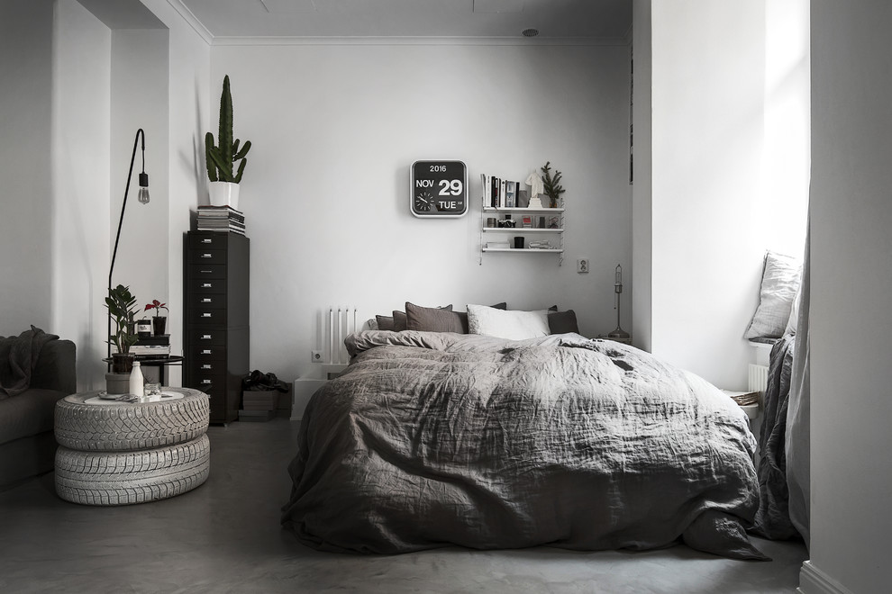 Example of a danish concrete floor bedroom design in Stockholm with white walls