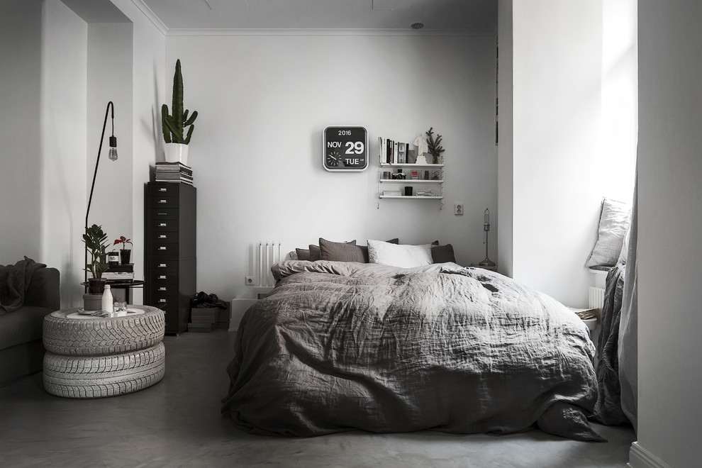 Scandi cream and black bedroom in Stockholm with white walls and concrete flooring.