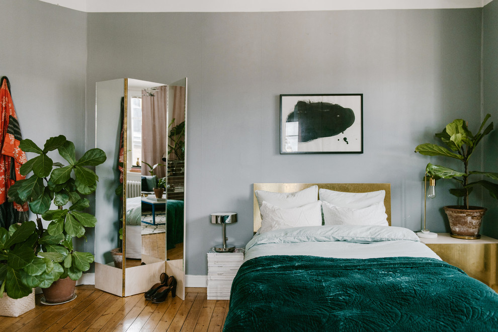 Idéer för små skandinaviska sovrum, med grå väggar och mellanmörkt trägolv