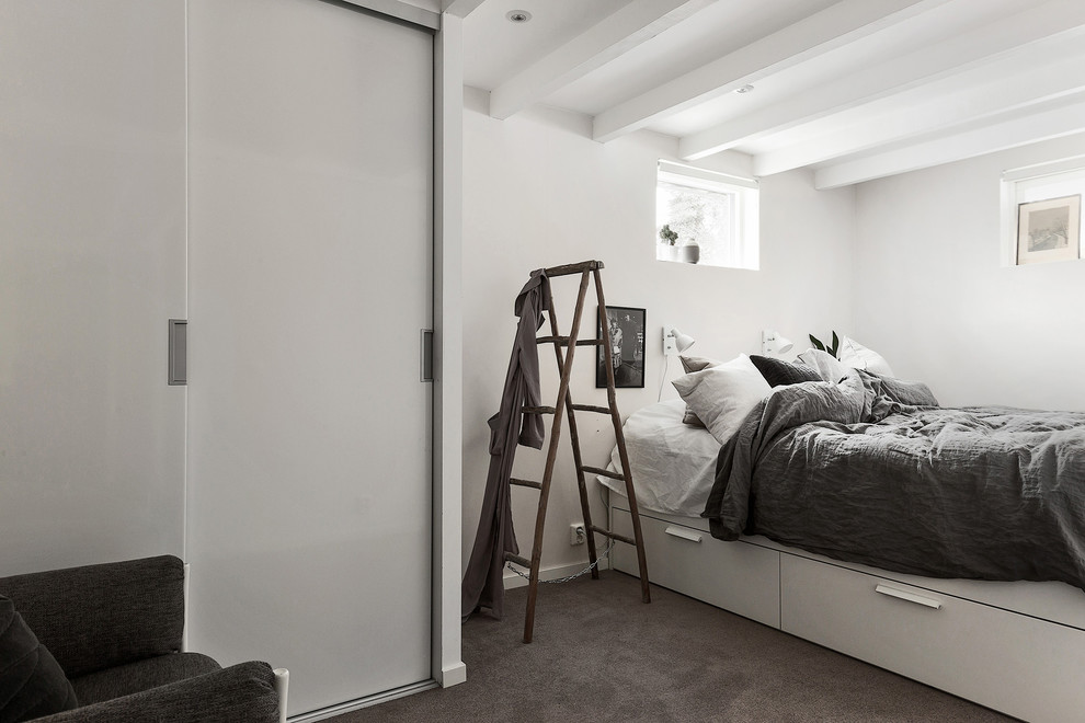 Imagen de dormitorio principal nórdico de tamaño medio con paredes blancas y moqueta