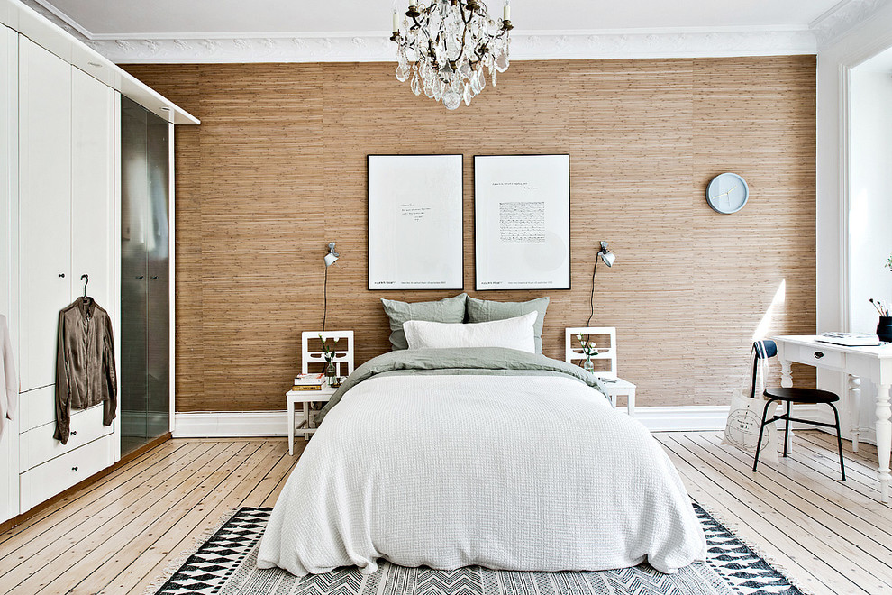 Modelo de dormitorio principal nórdico de tamaño medio sin chimenea con suelo de madera clara y paredes beige