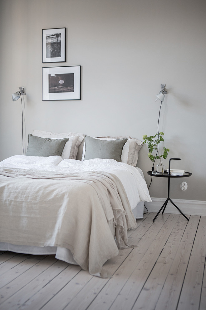 ヨーテボリにある広い北欧スタイルのおしゃれな主寝室 (グレーの壁、淡色無垢フローリング、暖炉なし) のレイアウト
