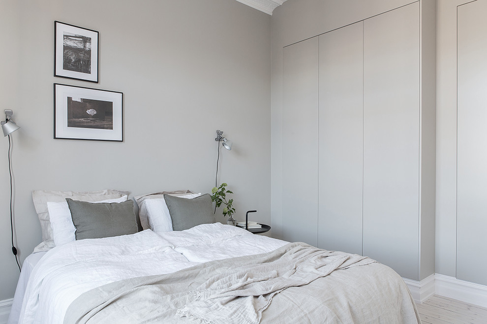 Cette photo montre une chambre victorienne avec un mur gris et parquet clair.