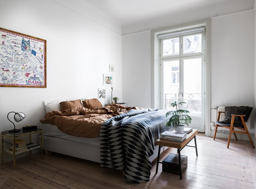 Modelo de dormitorio nórdico grande con paredes blancas, suelo beige y suelo de madera clara