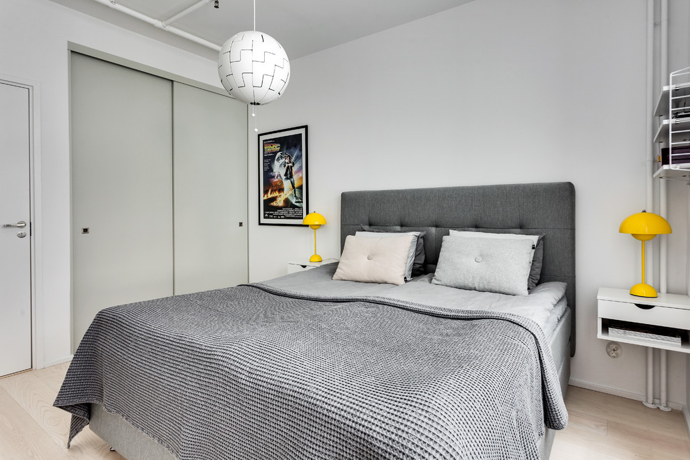 Modelo de dormitorio contemporáneo de tamaño medio con paredes blancas y suelo beige