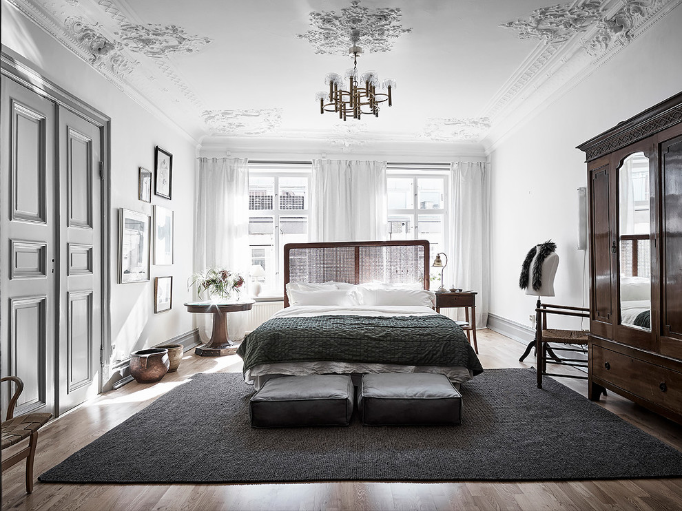 Идея дизайна: огромная хозяйская спальня в викторианском стиле с белыми стенами, паркетным полом среднего тона и коричневым полом без камина