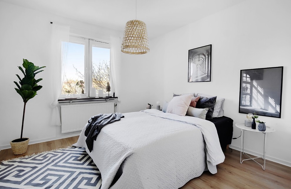 Пример оригинального дизайна: хозяйская спальня в скандинавском стиле с белыми стенами и светлым паркетным полом без камина