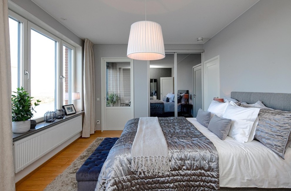 Foto di una camera degli ospiti design di medie dimensioni con pareti grigie, pavimento in legno massello medio e pavimento marrone