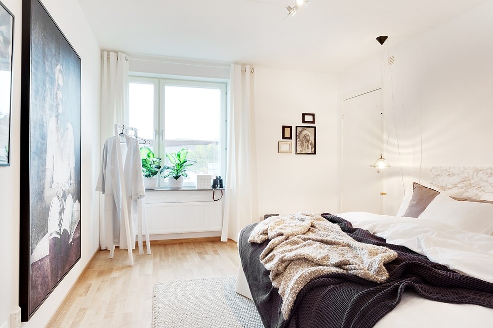 Ispirazione per una piccola camera matrimoniale scandinava con pareti bianche, pavimento in legno massello medio, nessun camino e pavimento marrone