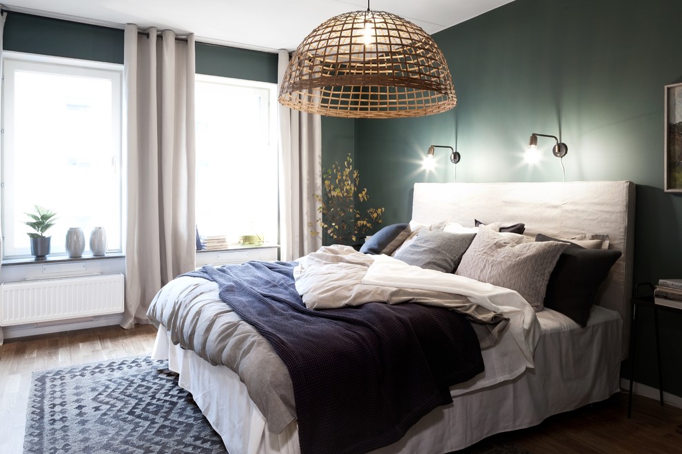 Foto de dormitorio principal contemporáneo de tamaño medio con paredes verdes, suelo de madera en tonos medios y suelo marrón