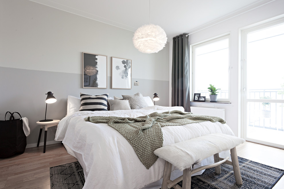 Mittelgroßes Nordisches Gästezimmer mit hellem Holzboden, weißer Wandfarbe und braunem Boden in Göteborg