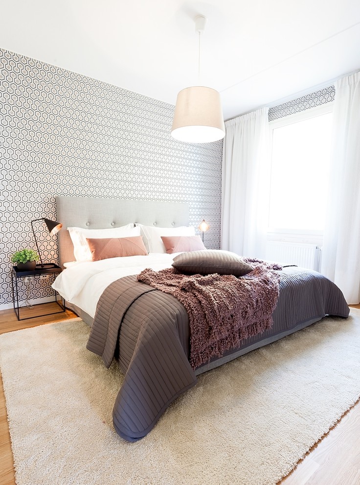 Foto de habitación de invitados escandinava de tamaño medio sin chimenea con suelo de madera en tonos medios y paredes multicolor