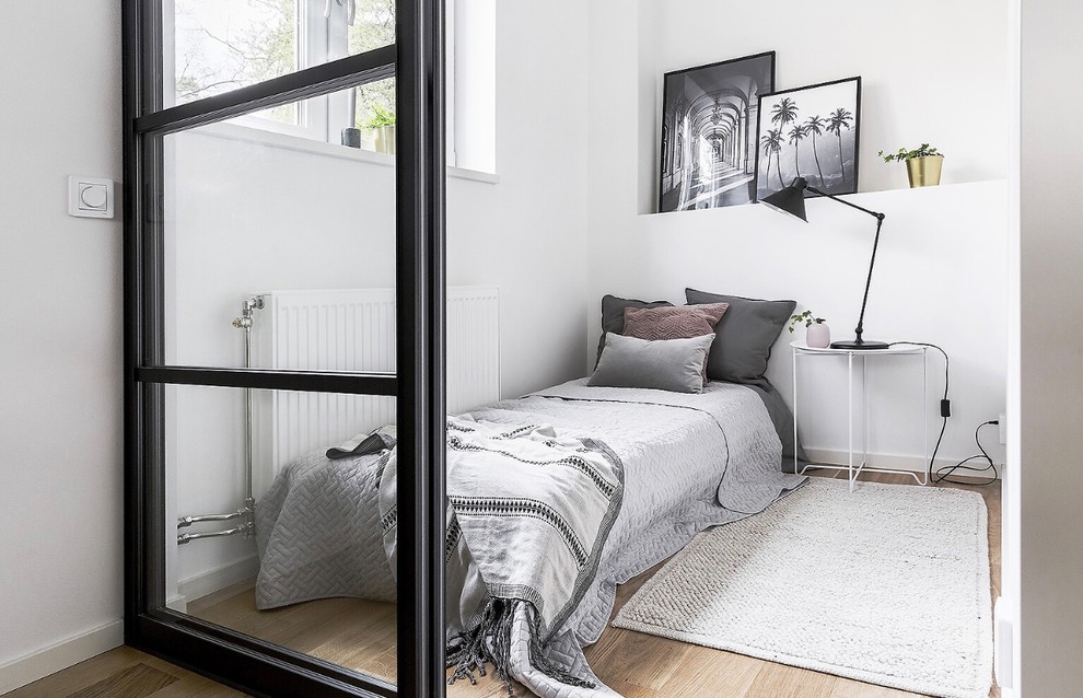 Aménagement d'une chambre scandinave avec un mur blanc, parquet clair et un sol beige.