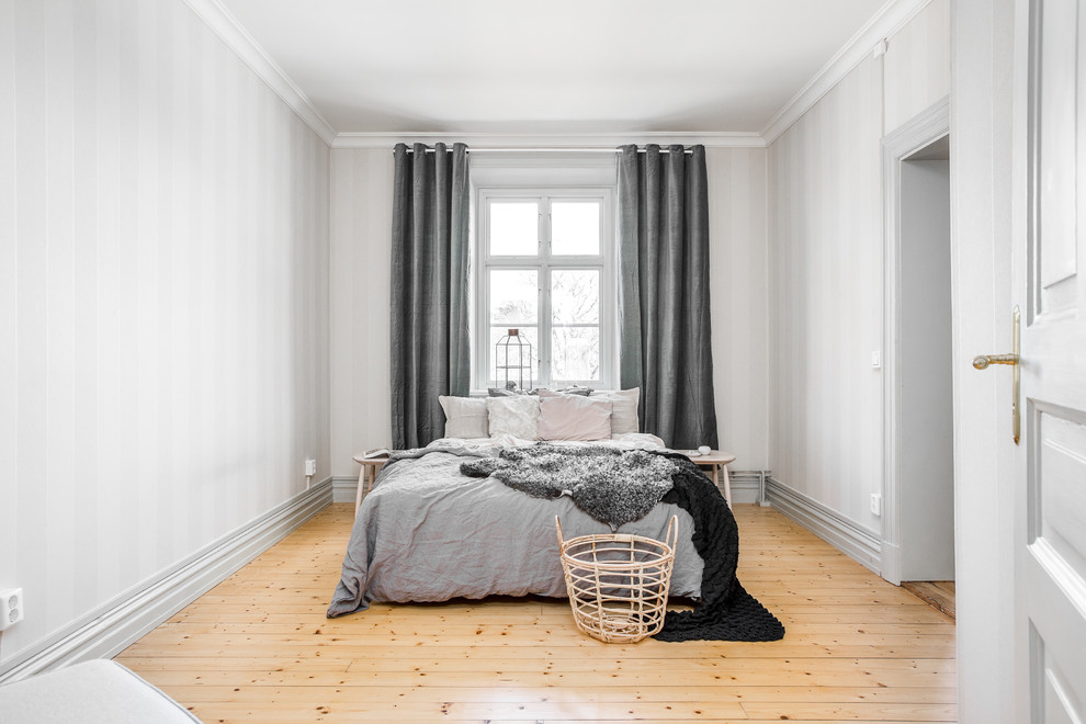 Diseño de dormitorio principal escandinavo con paredes blancas y suelo de madera clara