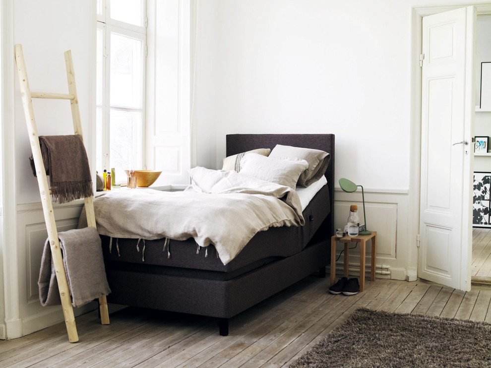 Ejemplo de dormitorio principal escandinavo de tamaño medio sin chimenea con paredes blancas y suelo de madera clara