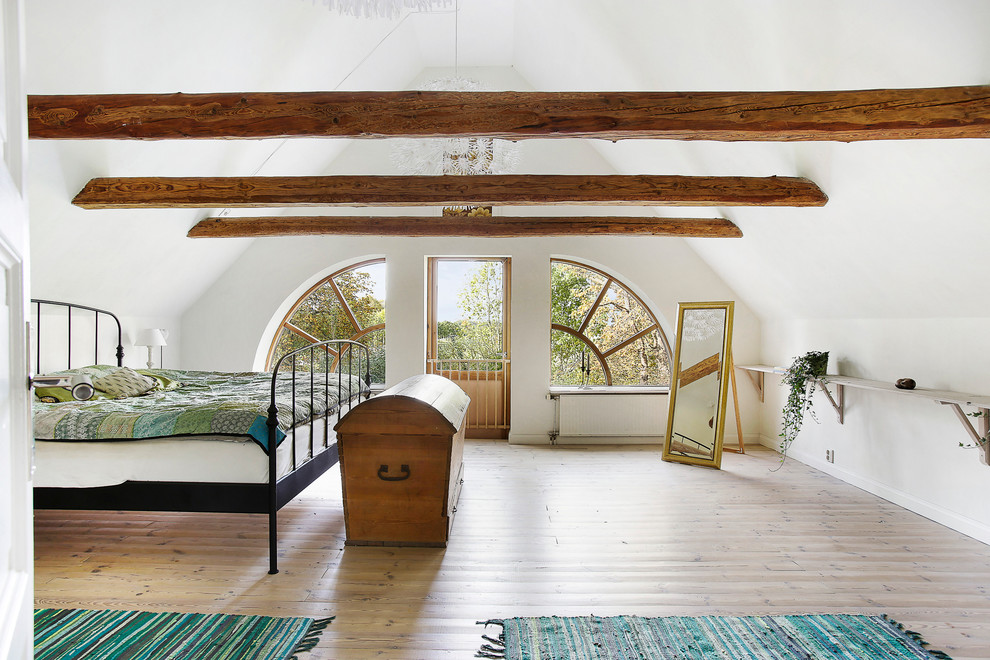 Esempio di una grande camera da letto stile loft nordica con pareti bianche e pavimento in legno massello medio