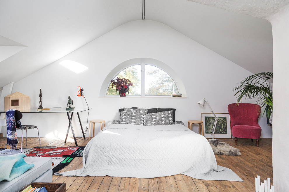 Eklektisches Hauptschlafzimmer ohne Kamin mit weißer Wandfarbe, braunem Holzboden und braunem Boden in Göteborg