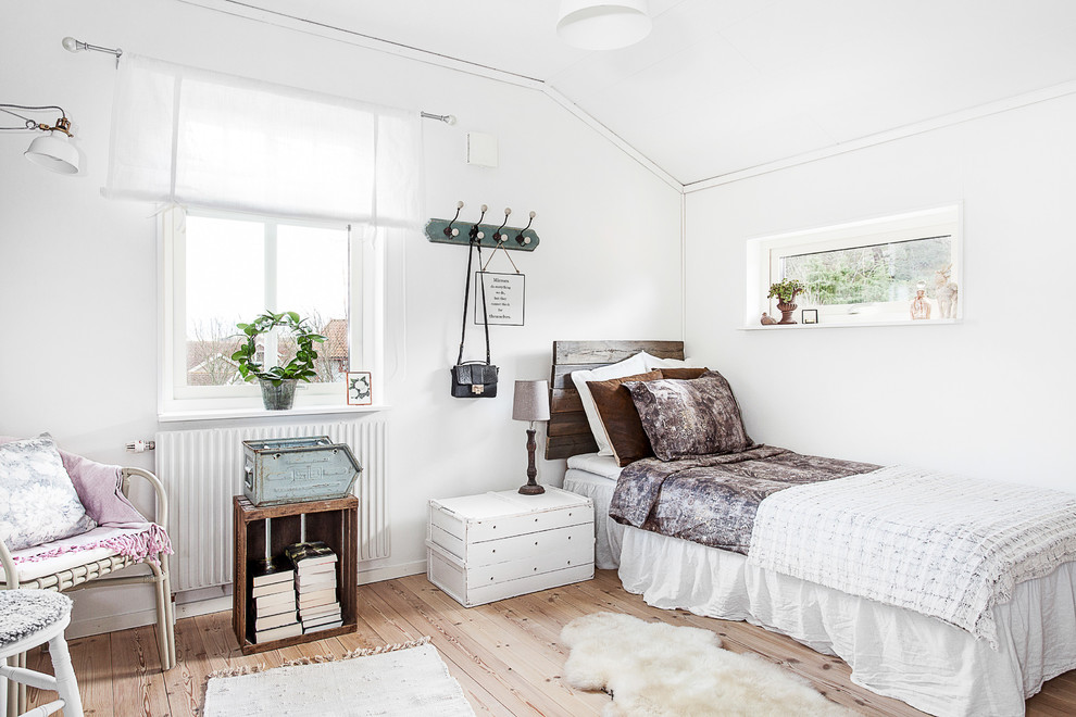Design ideas for a large scandinavian guest bedroom in Gothenburg with white walls and light hardwood flooring.