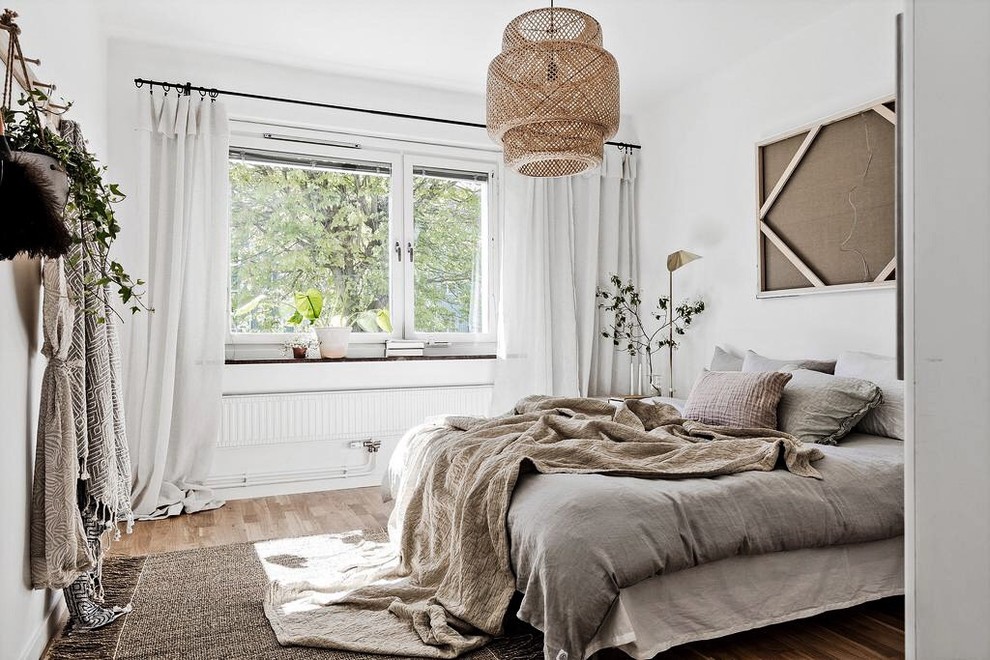 Scandi master bedroom in Gothenburg with white walls and medium hardwood flooring.