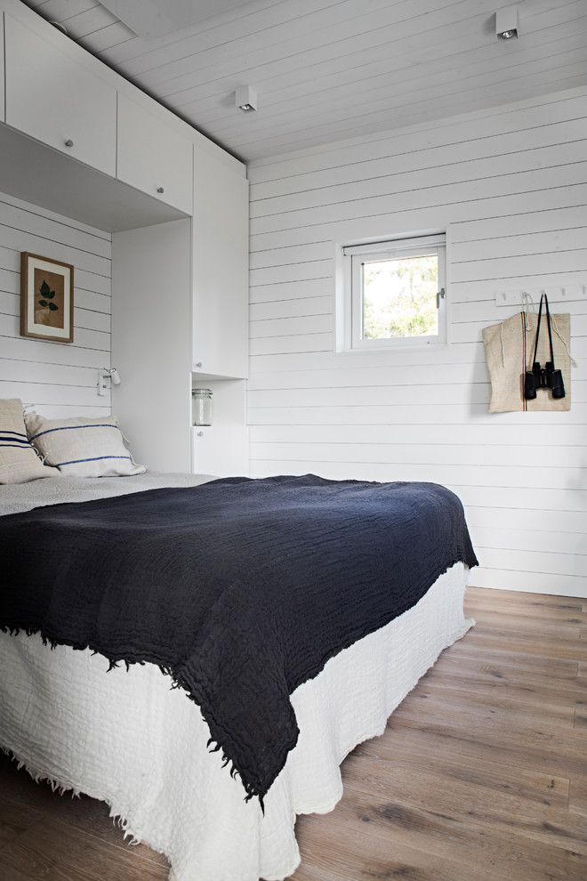 Mittelgroßes Skandinavisches Hauptschlafzimmer mit weißer Wandfarbe und hellem Holzboden in Stockholm