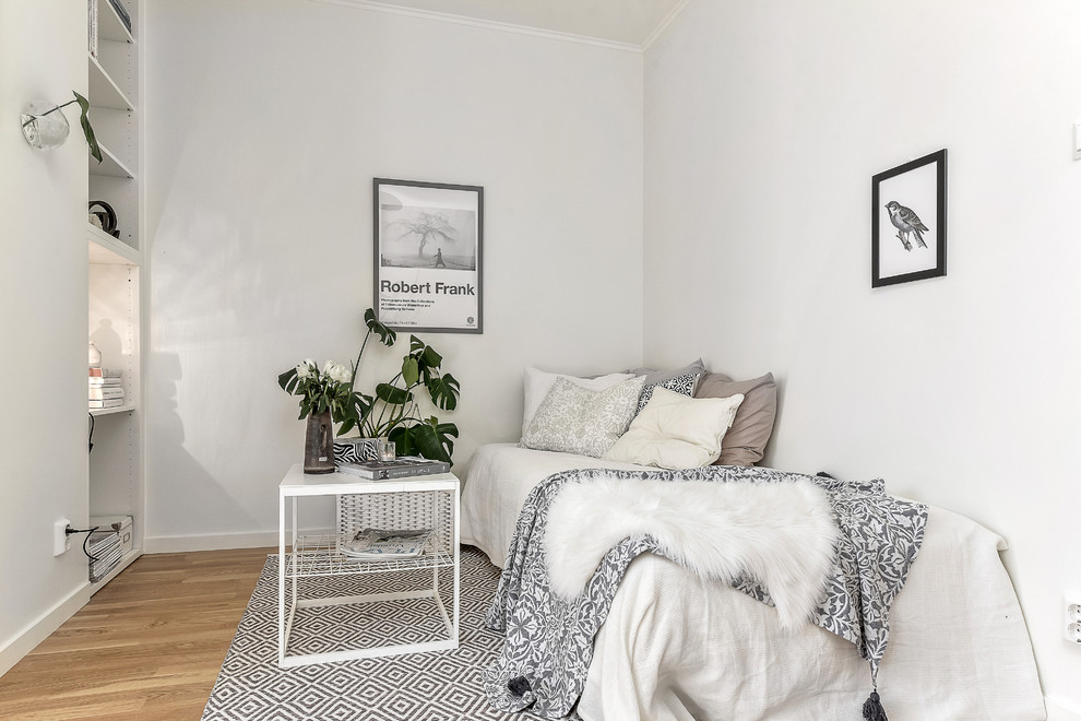Diseño de habitación de invitados escandinava de tamaño medio sin chimenea con paredes blancas y suelo de madera en tonos medios