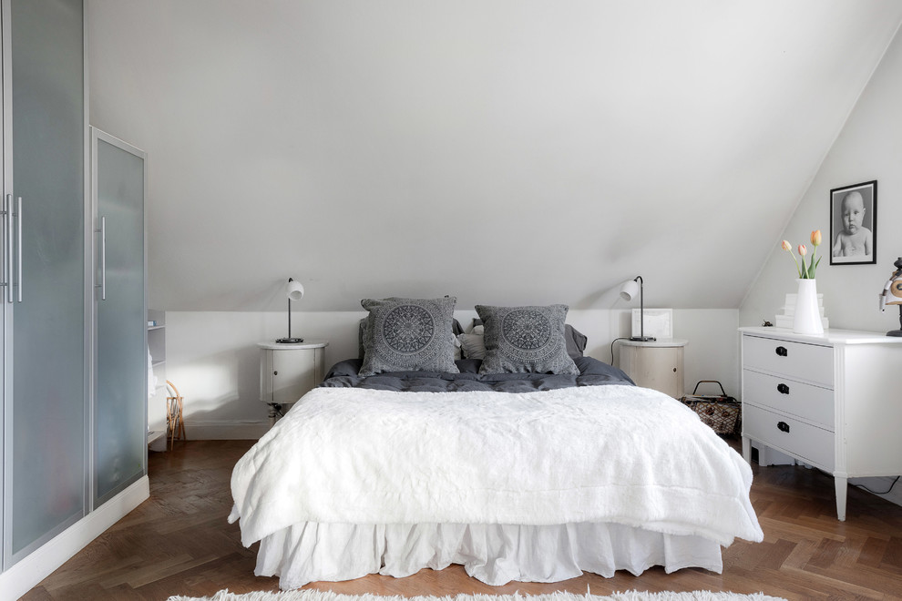 Esempio di una camera degli ospiti scandinava di medie dimensioni con pareti bianche, pavimento in legno massello medio e pavimento marrone