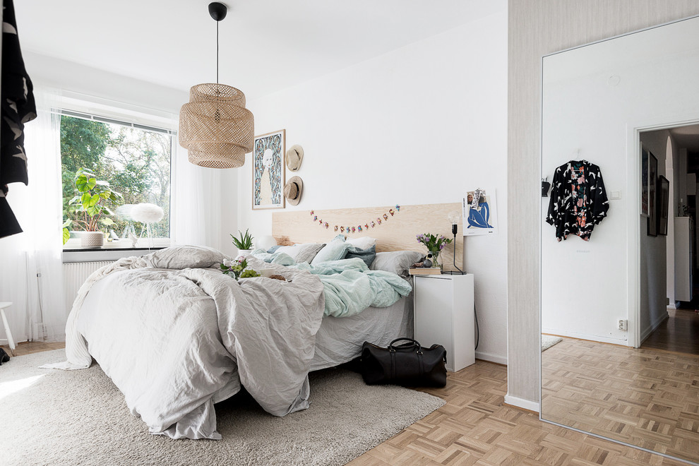 Ispirazione per una camera matrimoniale scandinava di medie dimensioni con pareti bianche, parquet chiaro e pavimento marrone