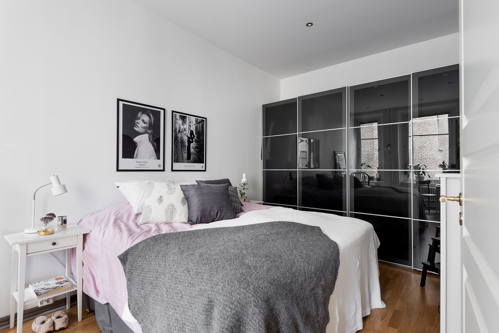 Imagen de dormitorio principal escandinavo grande con paredes blancas y suelo de madera en tonos medios