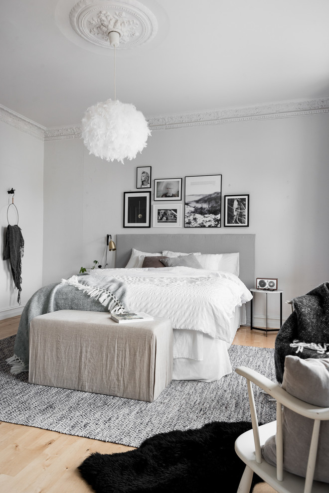 Réalisation d'une grande chambre parentale grise et blanche nordique avec un mur gris, parquet clair et aucune cheminée.