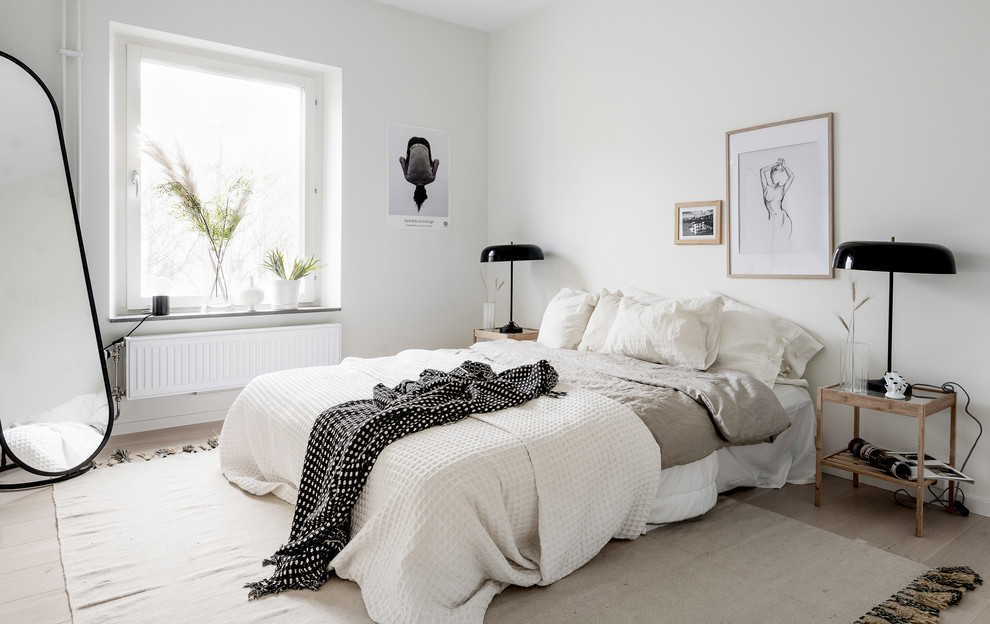 Mittelgroßes Nordisches Hauptschlafzimmer mit weißer Wandfarbe und hellem Holzboden in Göteborg