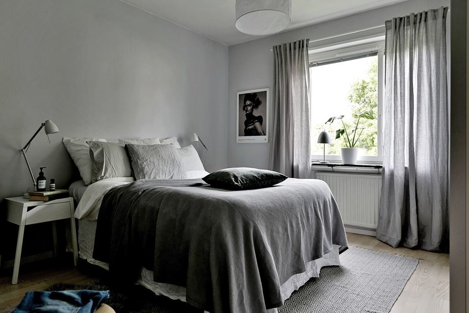 Skandinavisk inredning av ett mellanstort sovrum, med grå väggar, ljust trägolv och beiget golv