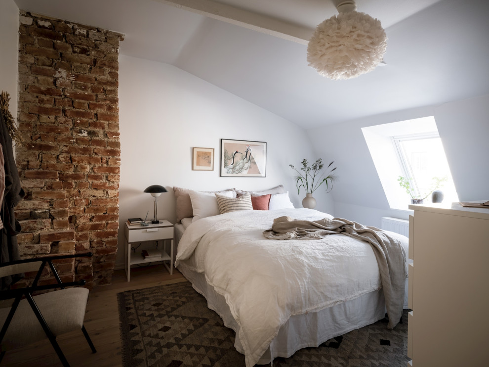 Стильный дизайн: спальня в скандинавском стиле с белыми стенами, паркетным полом среднего тона, коричневым полом и сводчатым потолком - последний тренд
