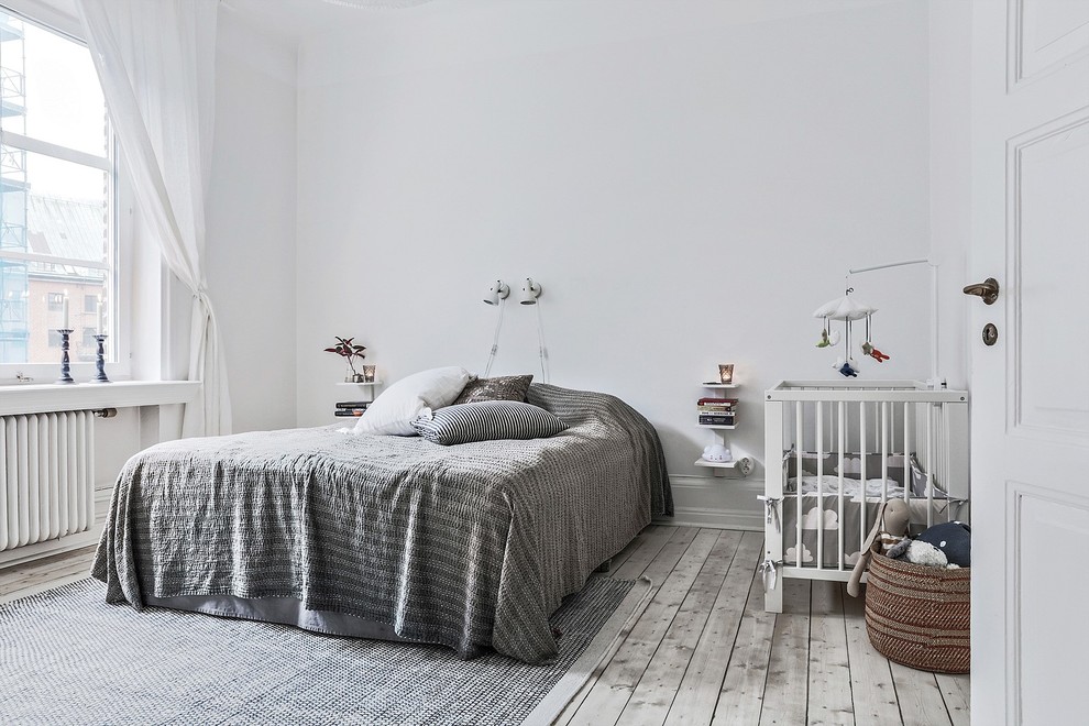 Bild på ett stort skandinaviskt huvudsovrum, med vita väggar, ljust trägolv och grått golv