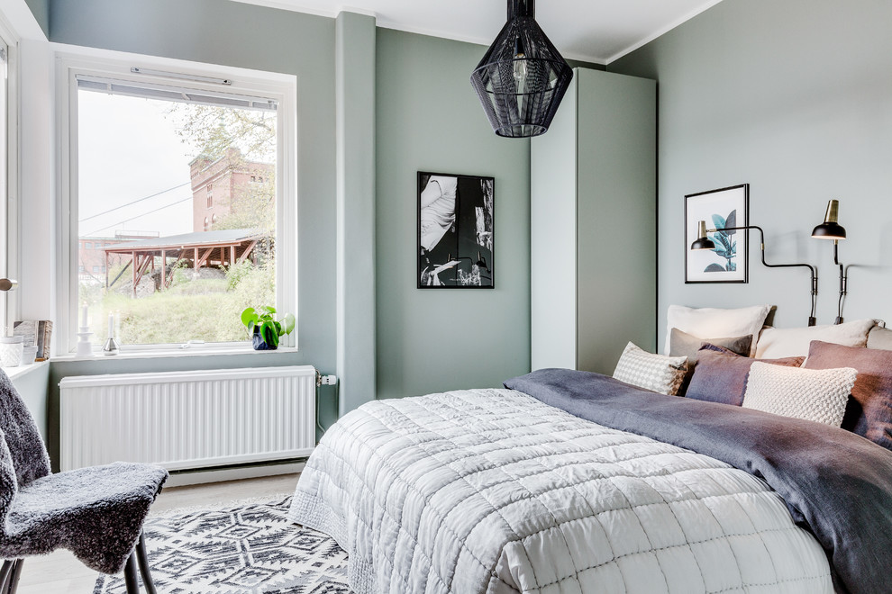 Idéer för ett mellanstort minimalistiskt gästrum, med gröna väggar och ljust trägolv