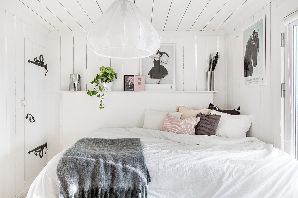 На фото: маленькая хозяйская спальня в скандинавском стиле с белыми стенами для на участке и в саду