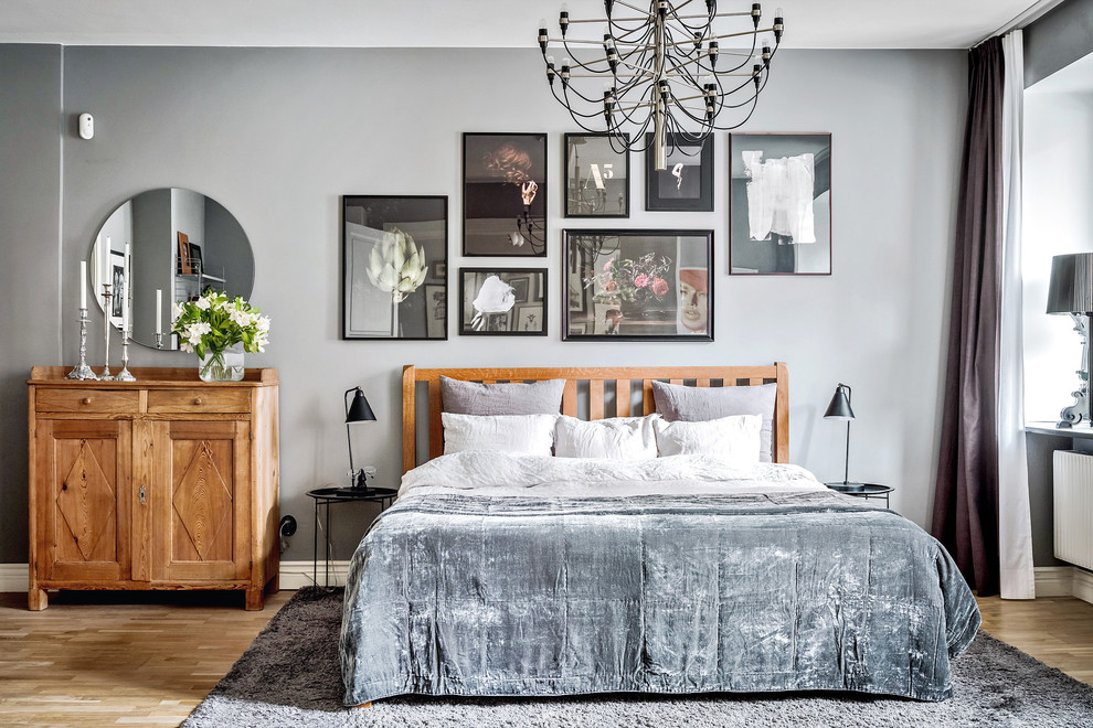 Ejemplo de dormitorio principal tradicional renovado grande con paredes grises, suelo de madera en tonos medios y suelo beige
